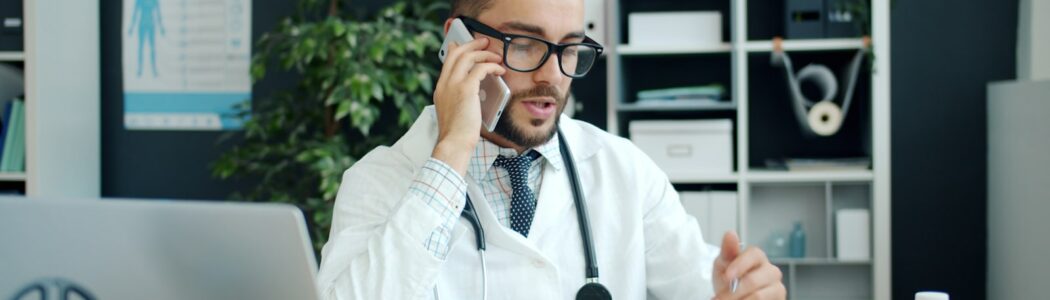 Médecin répondant au téléphone à son bureau, dans son cabinet